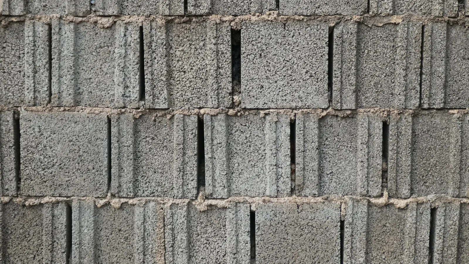 Close-up of a gray cinder block wall with rough mortar joints